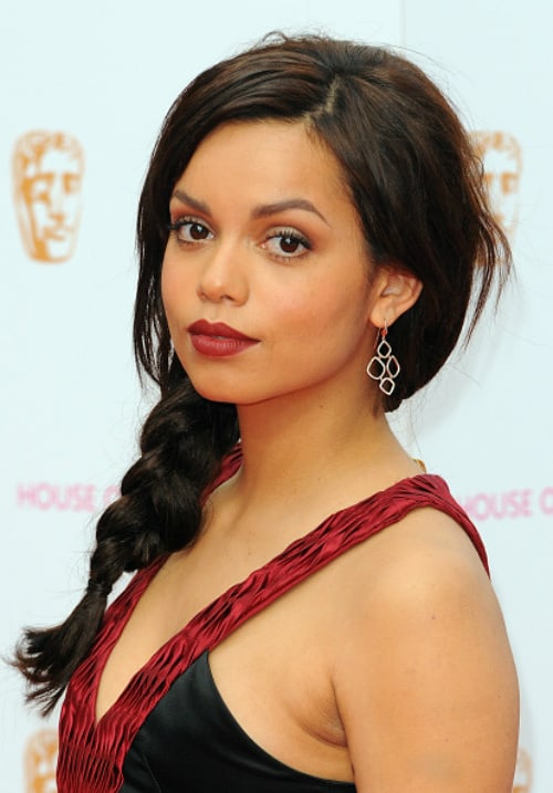 Georgina Campbell profile picture wearing black and maroon sleeveless dress and maroon lipstic, paired with braided hair and elegant earrings
